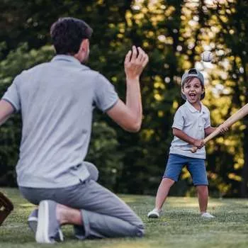 father playing baseball with child
