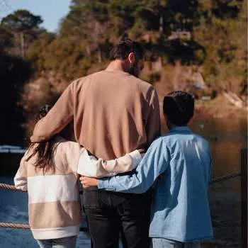 Picture of a father with two kids standing on a bridge