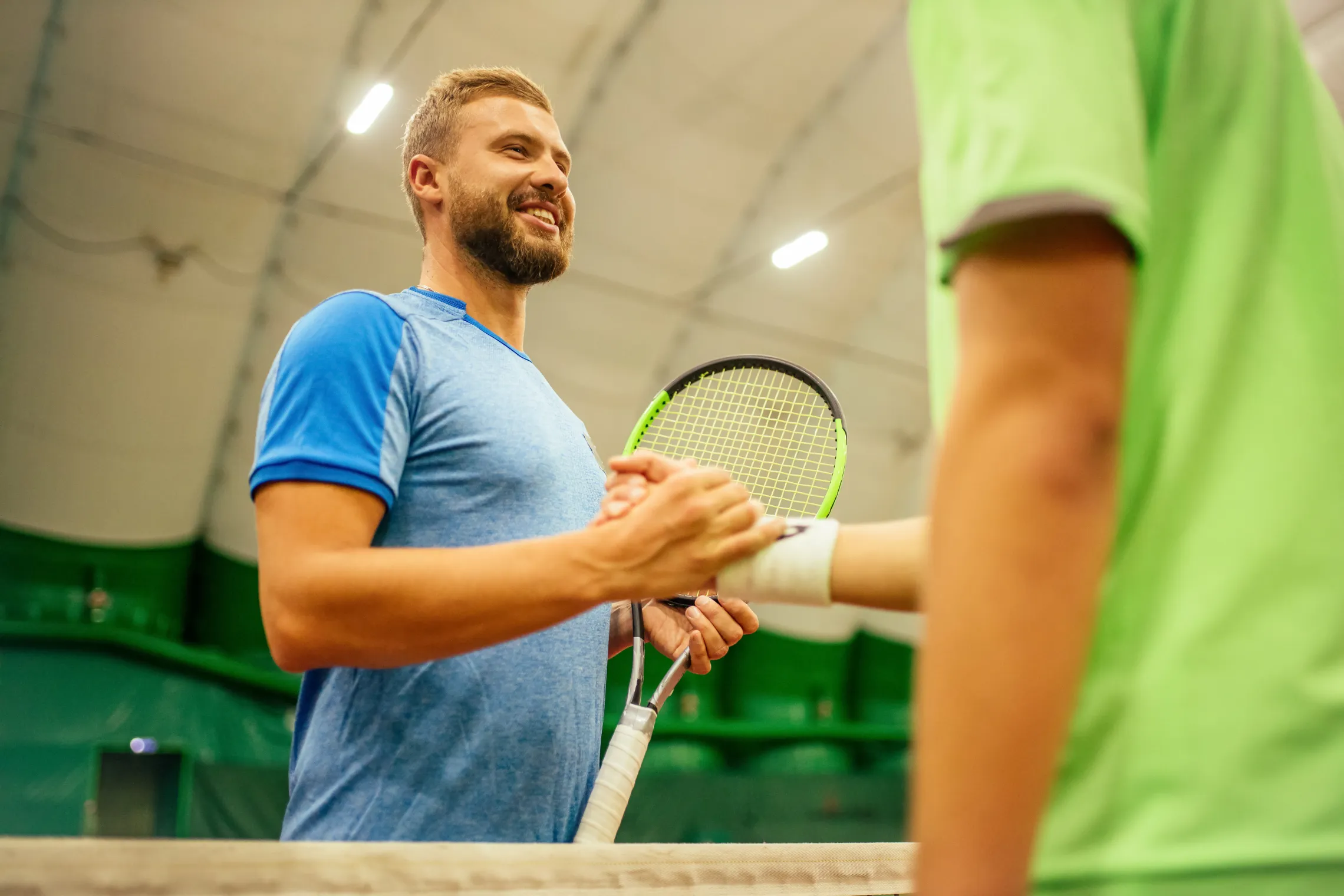 Smiling tennis player shaking hands across the net