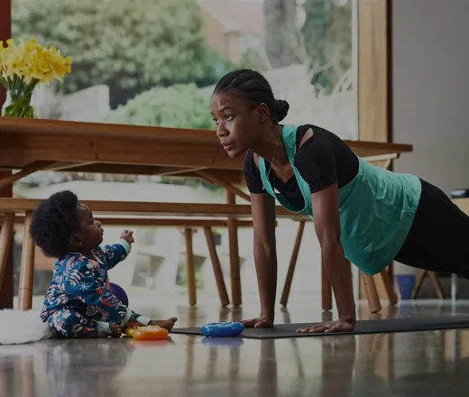 Mother exercising at home with baby on the floor