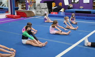 Chldren stretch in gymnastics class