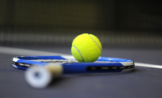 A close up image of a tennis ball and racket