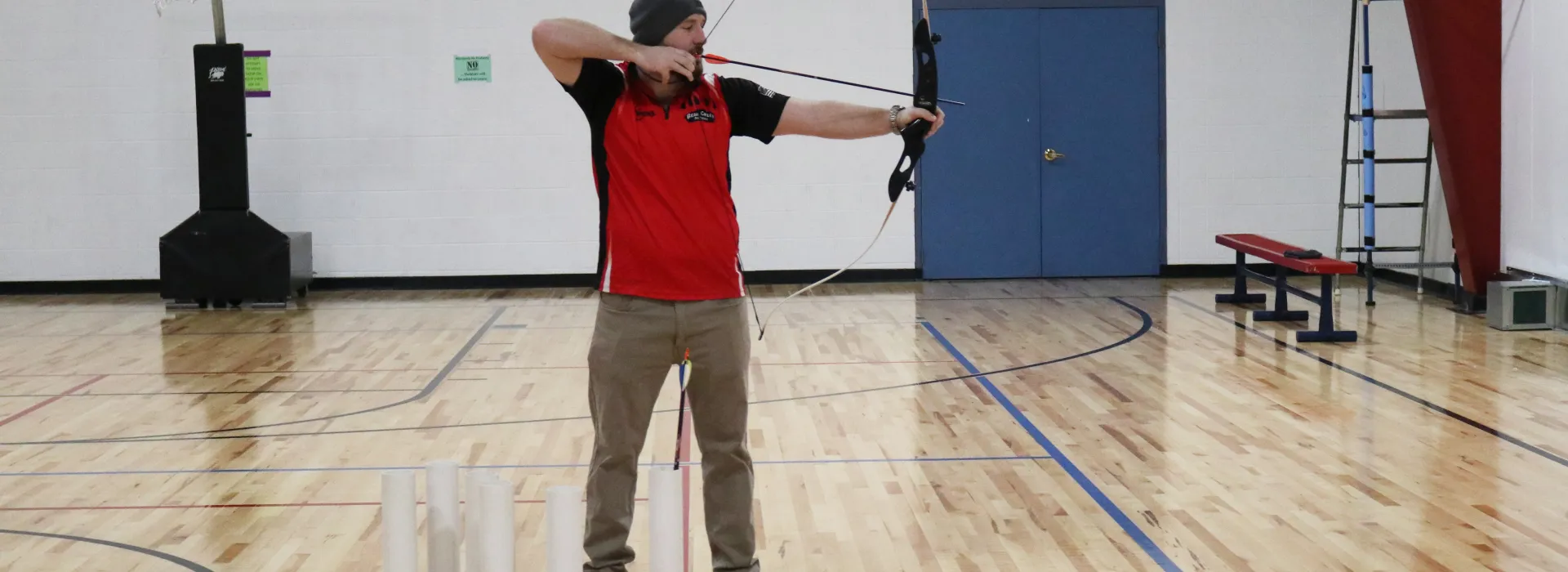 a man shows how to shoot a bow and arrow