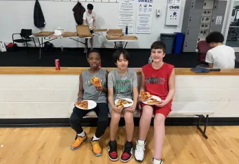 Teens eating pizza at March Madness event