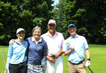 2 ladies and 2 men in a golf foursome smiling together