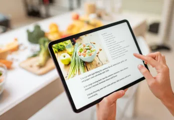 recipe on an ipad in a kitchen with food prep out on counter