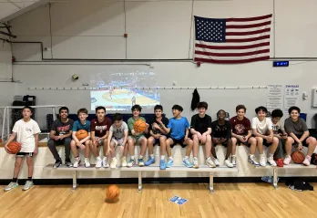 Teens lined up smiling at the Wells Ave Y teen's basketball night