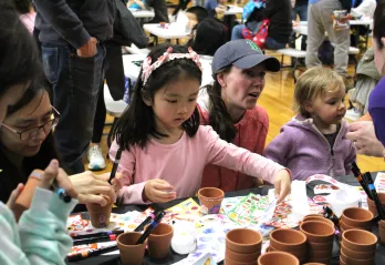 children and guardians decorating clay flower pots at Healthy Kids Day 2025