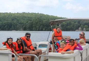Camp Frank A. Day family camp participants on a pontoon boat ride