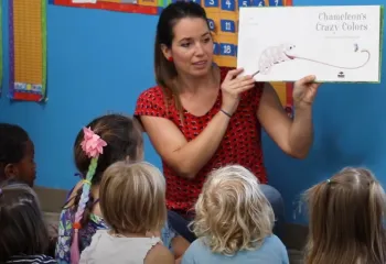 A preschool teacher reads a story to a group of children