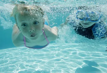A girl and a boy swimming underwater