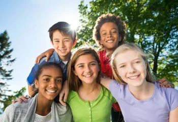 Group of young teens smiling together outside