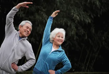 2 people stretching with their arm up