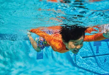 kid swimming underwater during laps at the YMCA Newton, MA