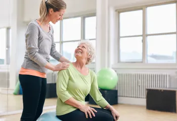 Trainer working with person and an exercise ball