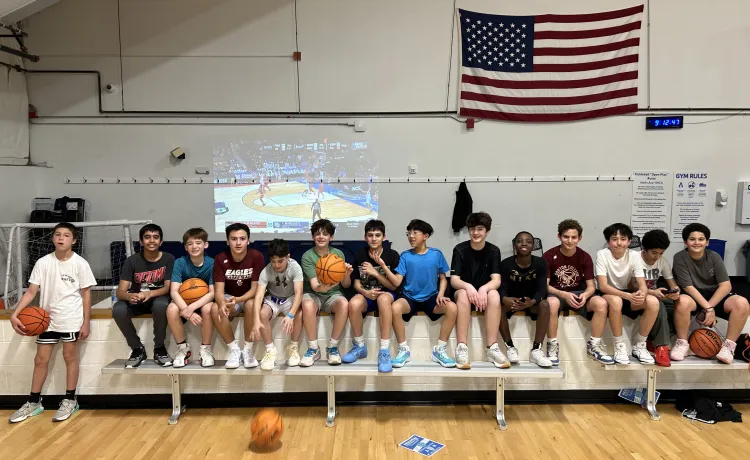 Teens lined up smiling at the Wells Ave Y teen's basketball night
