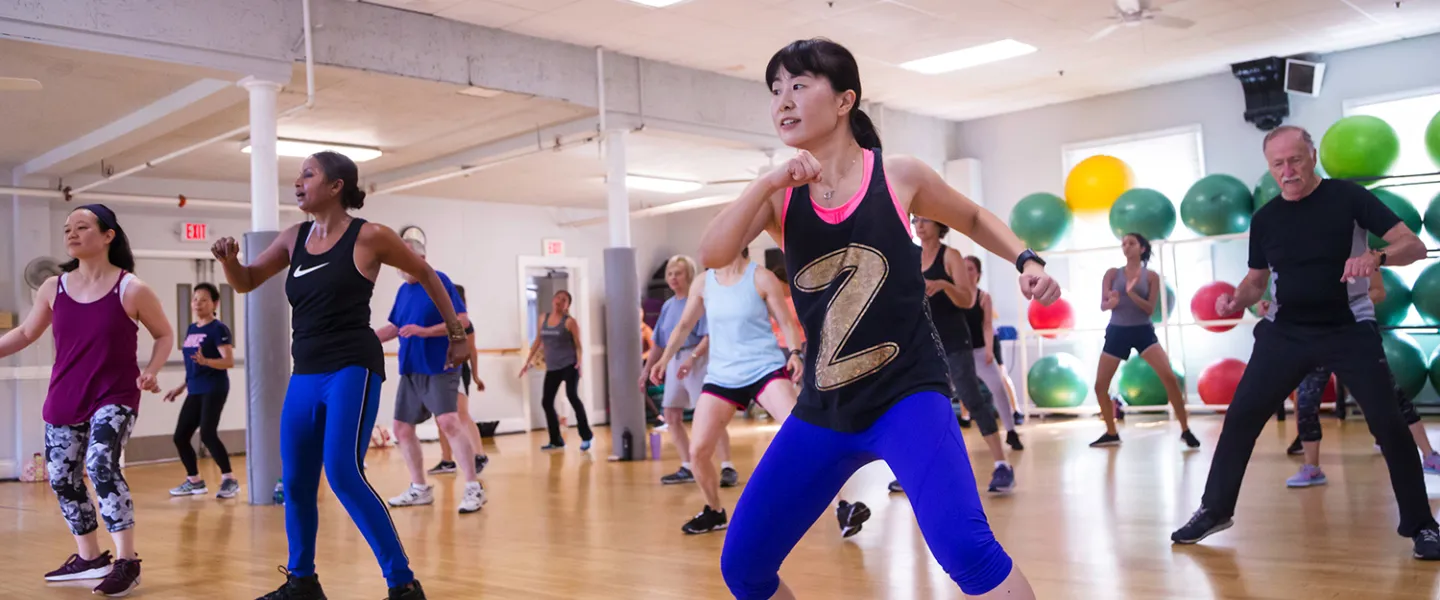 A diverse group of adults participate in a lively Zumba fitness class