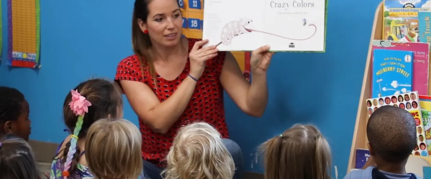A preschool teacher reads a story to a group of children