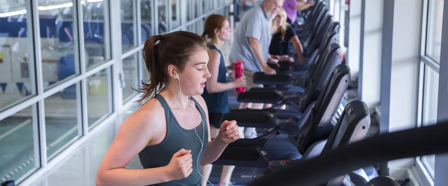 A young woman runs on a treadmill