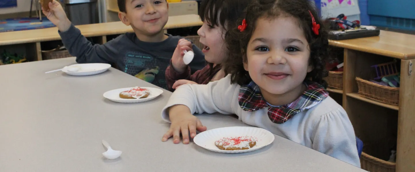 preschoolers decorating a cookie for the holidays
