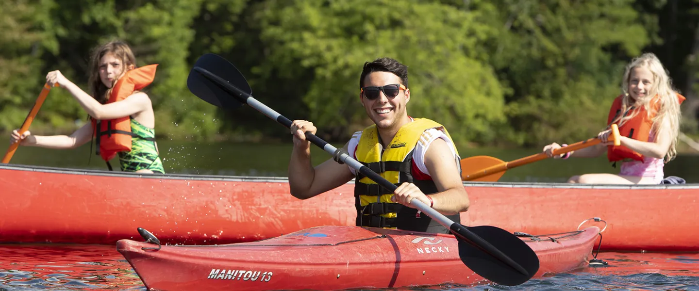 Two campers and one consular venture off into the lake on their own kayaks.