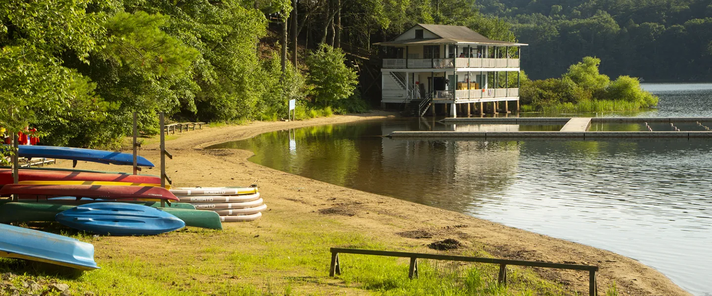 A nice picture of the CFAD lake, a cabin and a lot of canoes and kayaks.