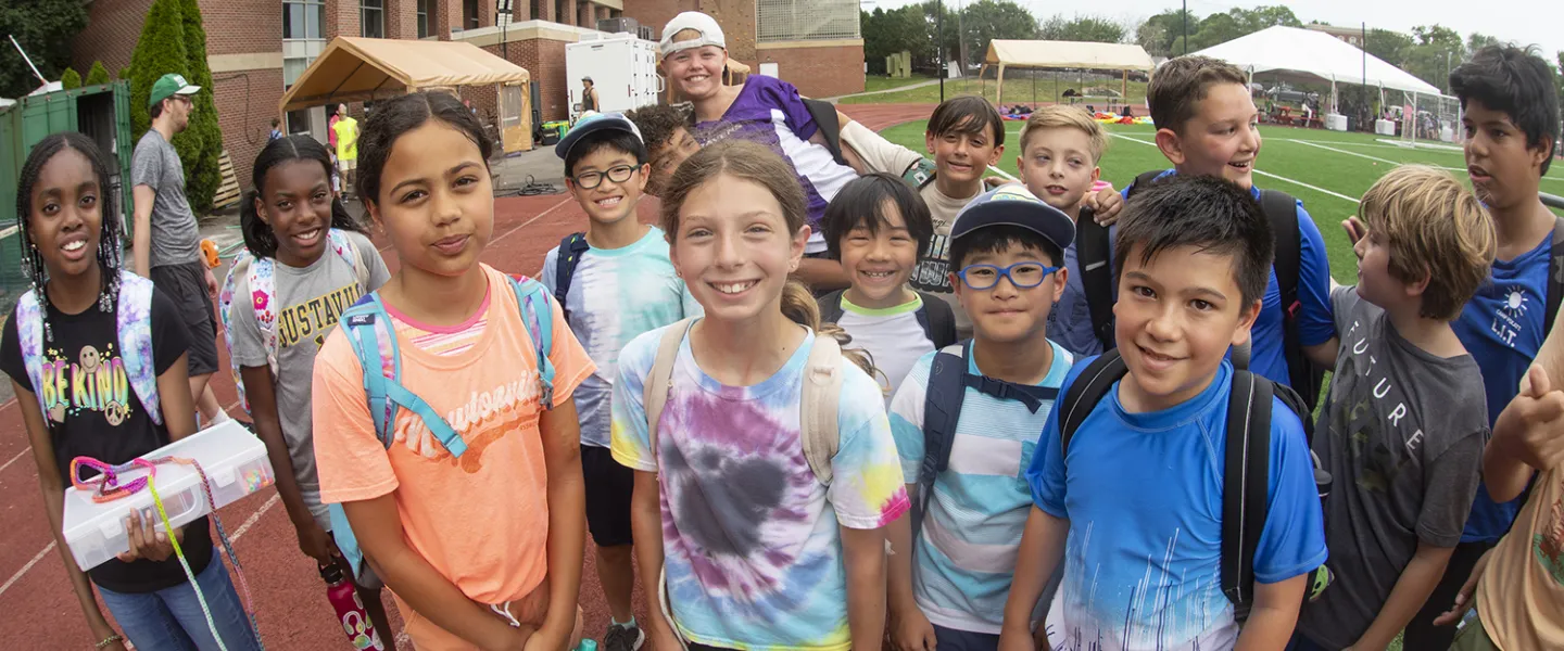 A group of campers and their few consulars gathered together by the building.