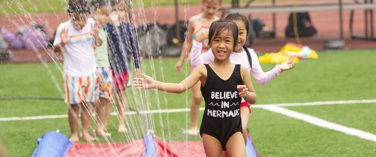 Young campers go running down the slip n' slide.