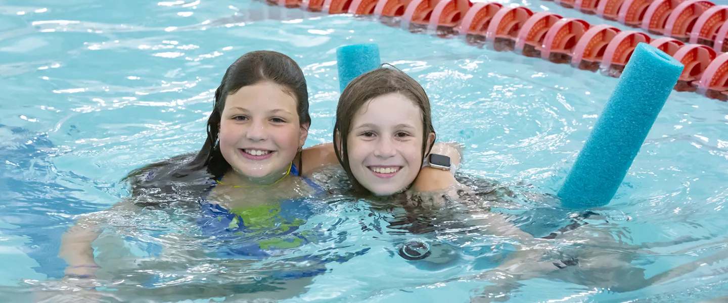 Two campers floating in the pool.