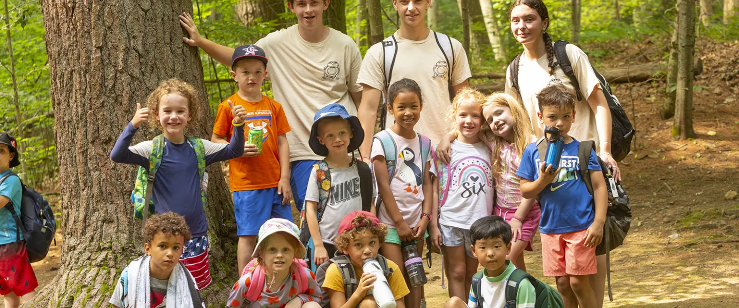 Consulars standing in the woods with their group of campers.