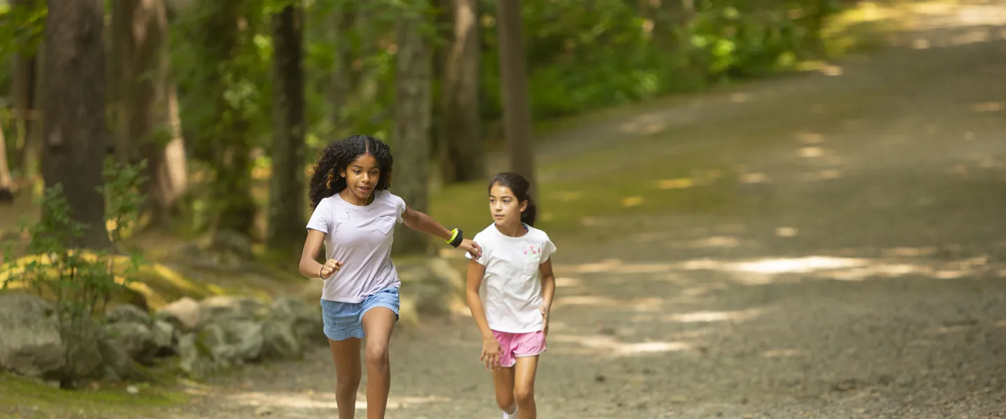 Two campers running down the path towards their group.