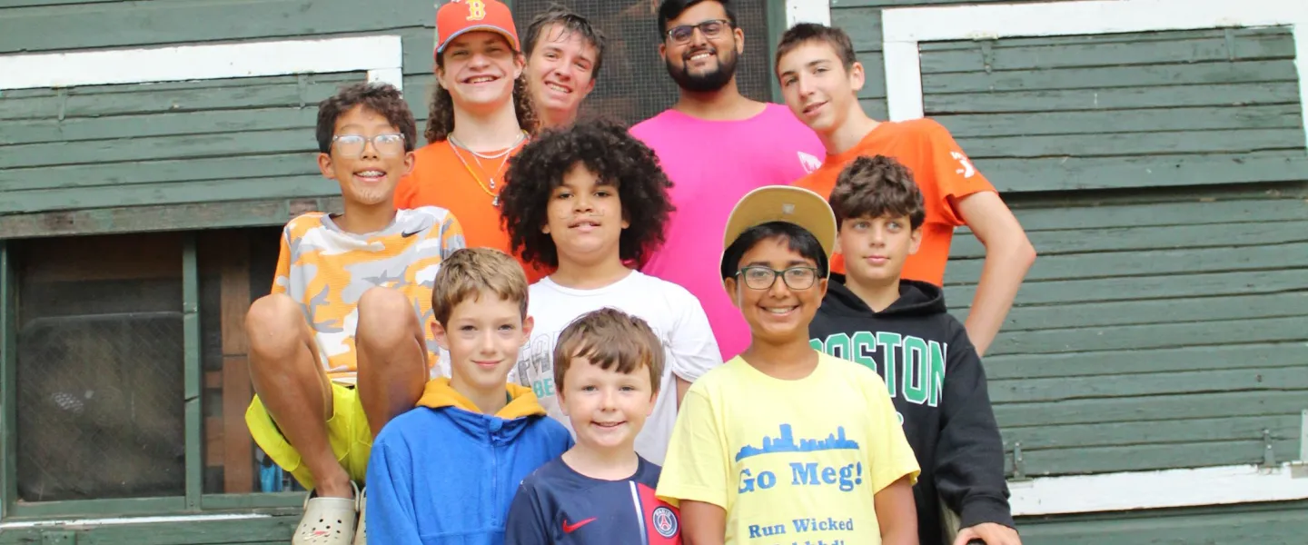 Some campers and consulars pose outside of their cabin. 