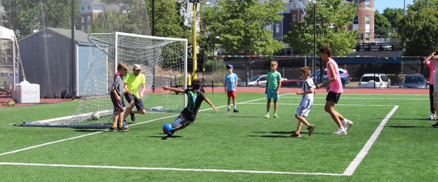 A bunch of campers and consulars together playing a pickup soccer game.