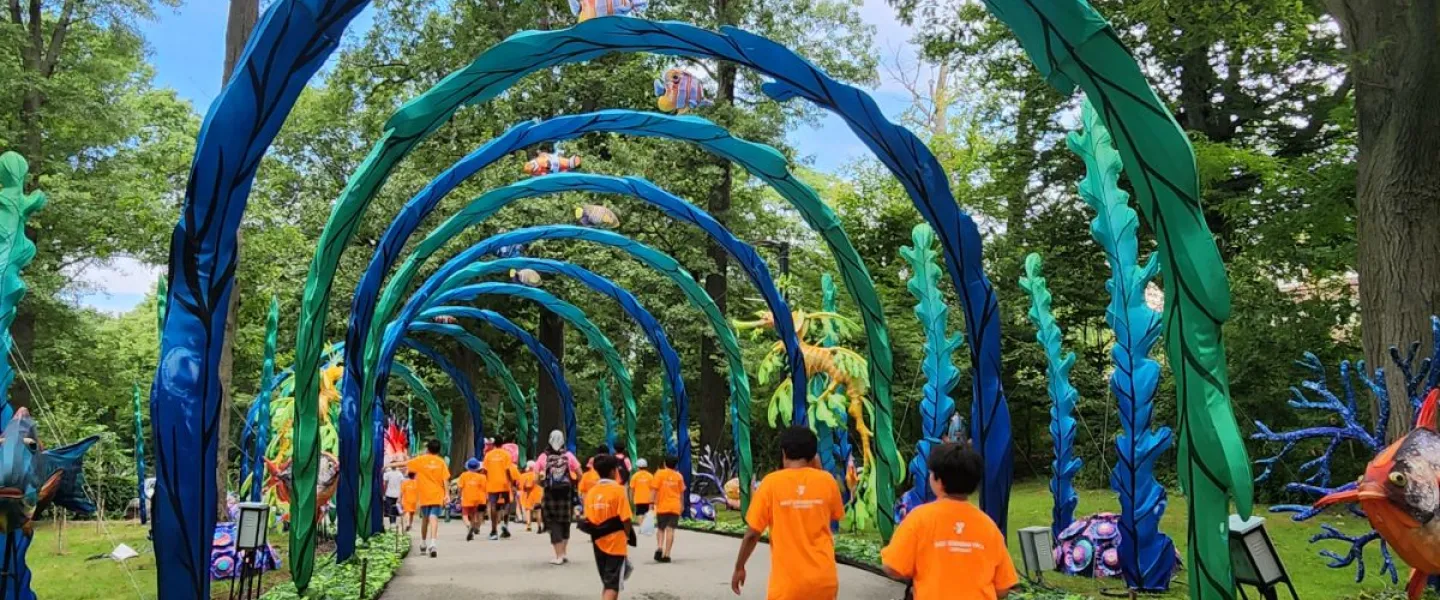 Campers walk under an ocean themed canopy. 