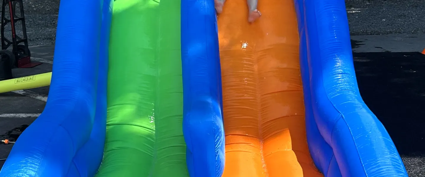 Camper going down the inflatable waterslide. 