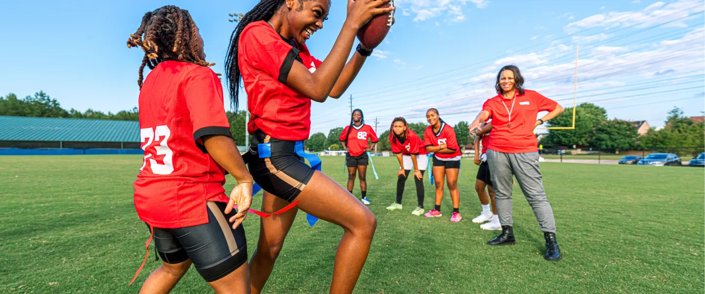Young teens playing flag football outside