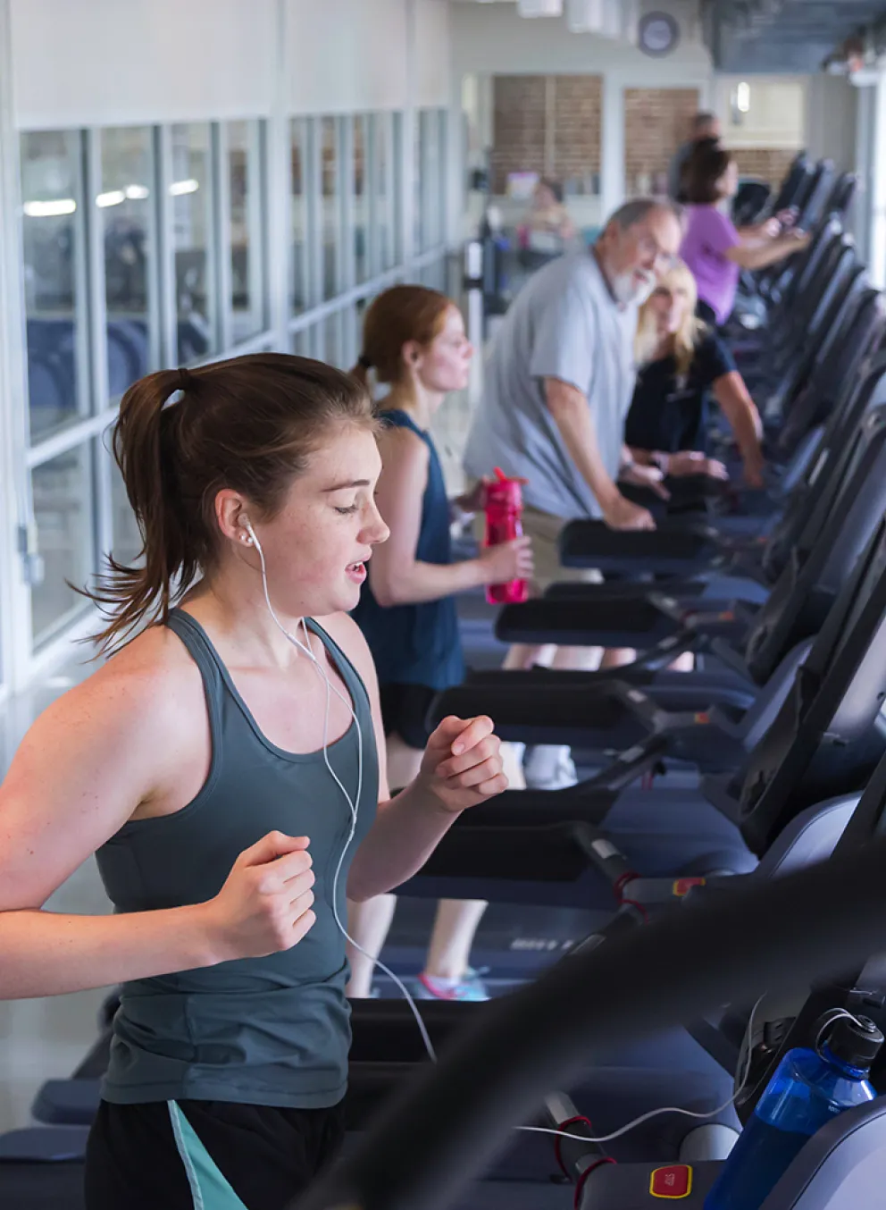 A young woman runs on a treadmill