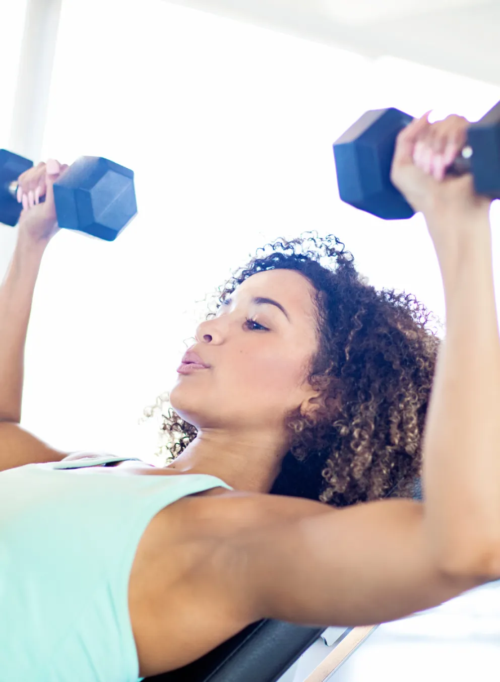 Woman doing chest press with free weights for the Women and Weights class