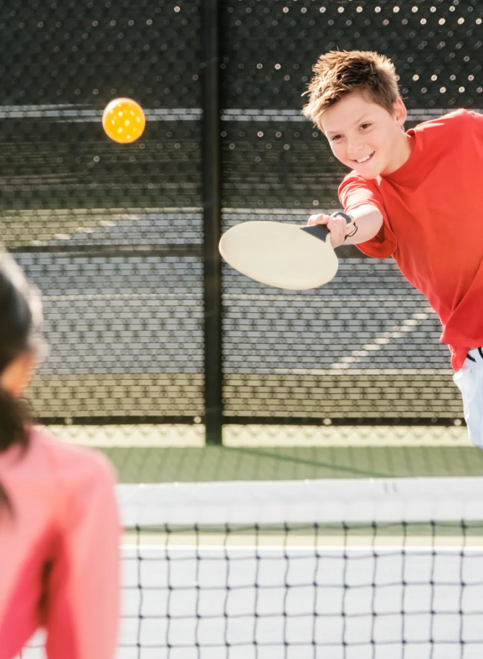 Young teens playing pickleball