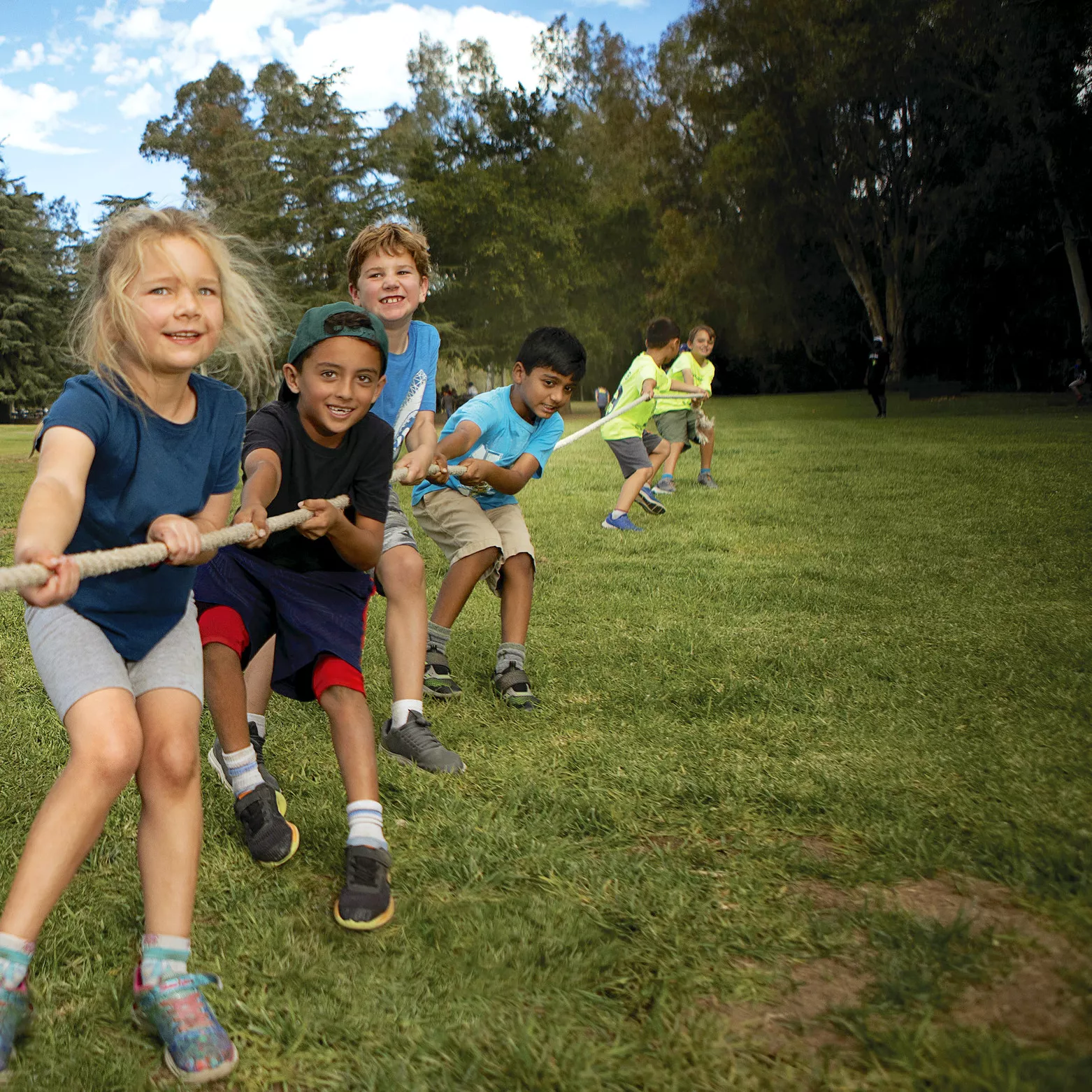 A group of kids pull on a rope in a game of tug-of-war