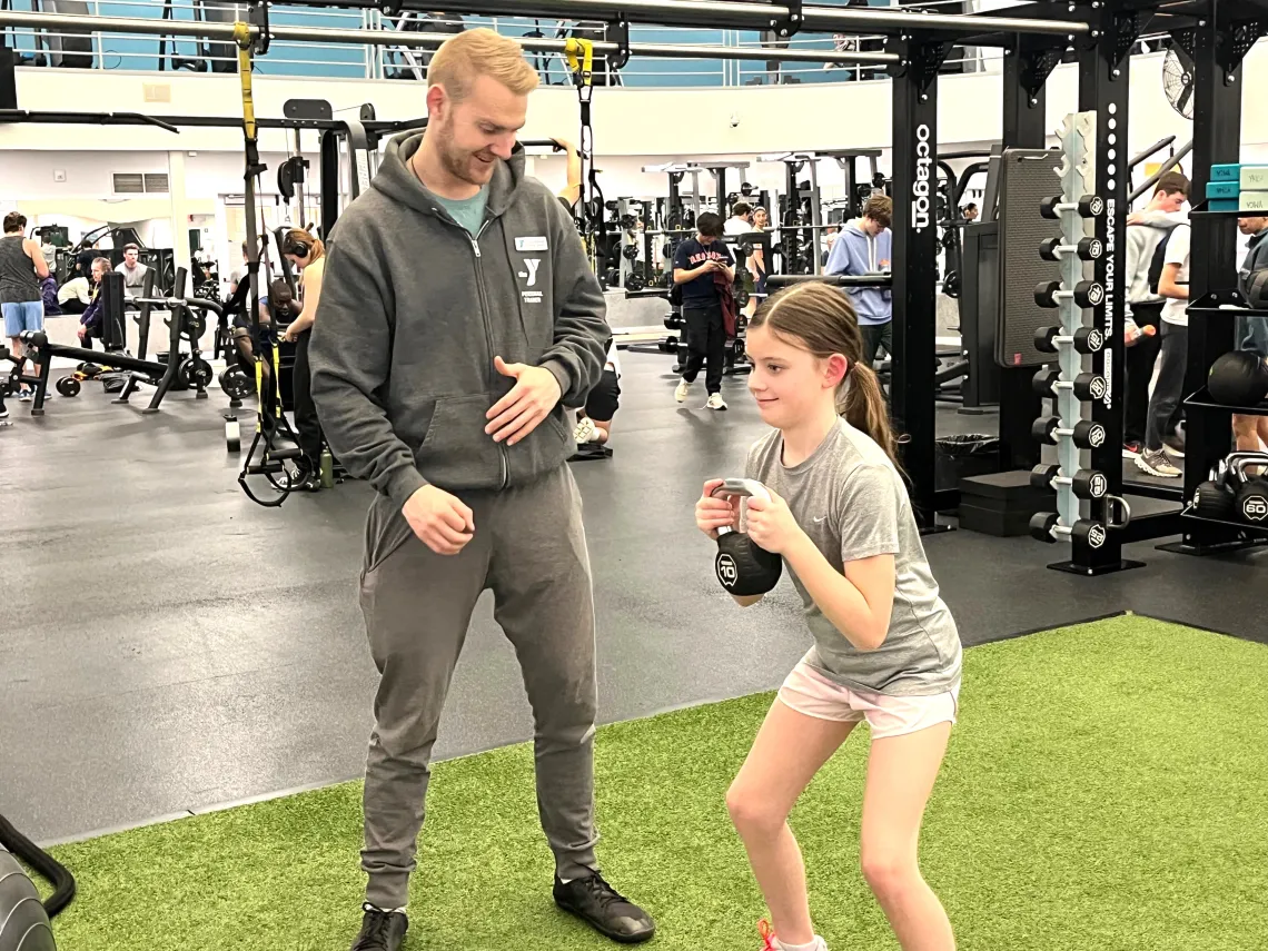 youth working with personal trainer at Wells Ave Y