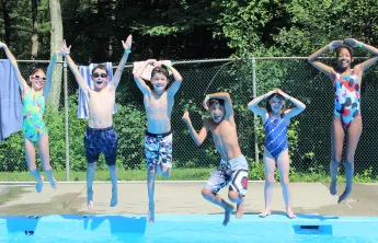 Campers jumping into the pool at Chickami