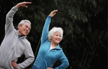 2 people stretching with their arm up