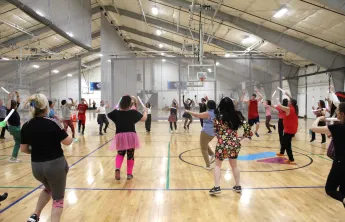 Dance for a Cause 2025 participants dancing in the Wells Ave Y gymnasium