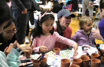 children and guardians decorating clay flower pots at Healthy Kids Day 2025