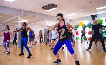 A diverse group of adults participate in a lively Zumba fitness class