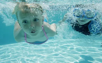 A girl and a boy swimming underwater