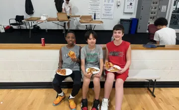 Teens eating pizza at March Madness event