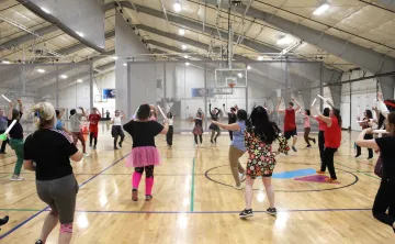 Dance for a Cause 2025 participants dancing in the Wells Ave Y gymnasium
