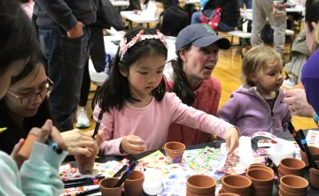 children and guardians decorating clay flower pots at Healthy Kids Day 2025